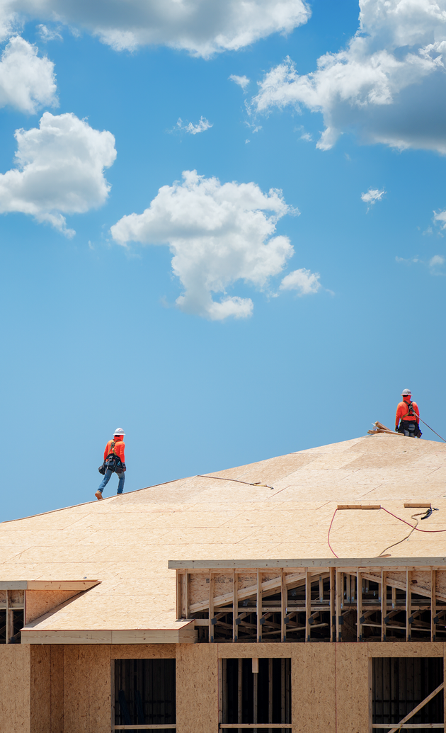 Roofers on top of luxury home